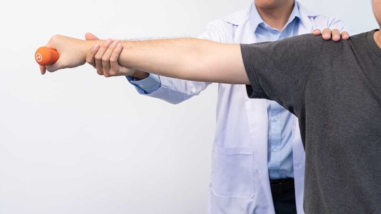 A local adult performing gentle knee stretches with a physical therapist in a bright clinic setting.
